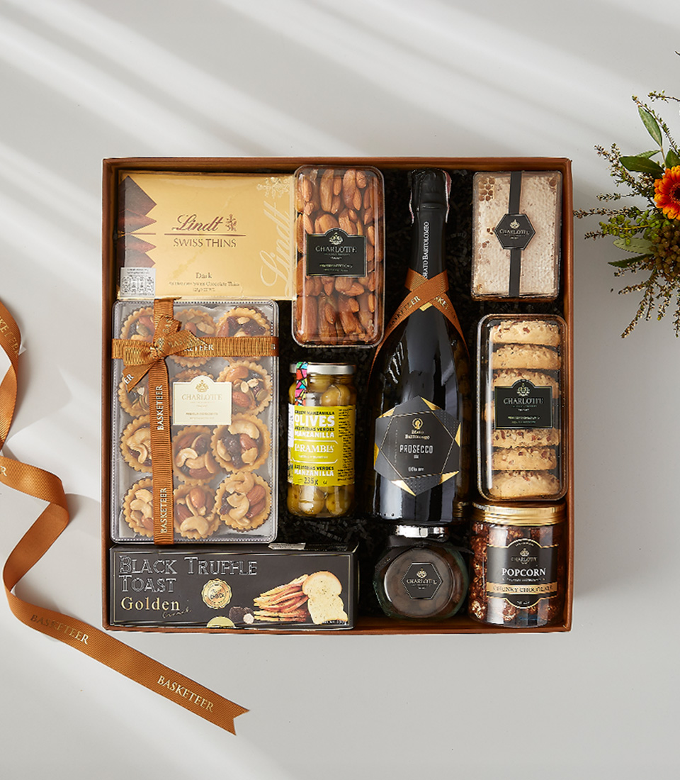 A luxurious and elegant gift basket filled with a bottle of wine, gourmet snacks, and holiday decorations.