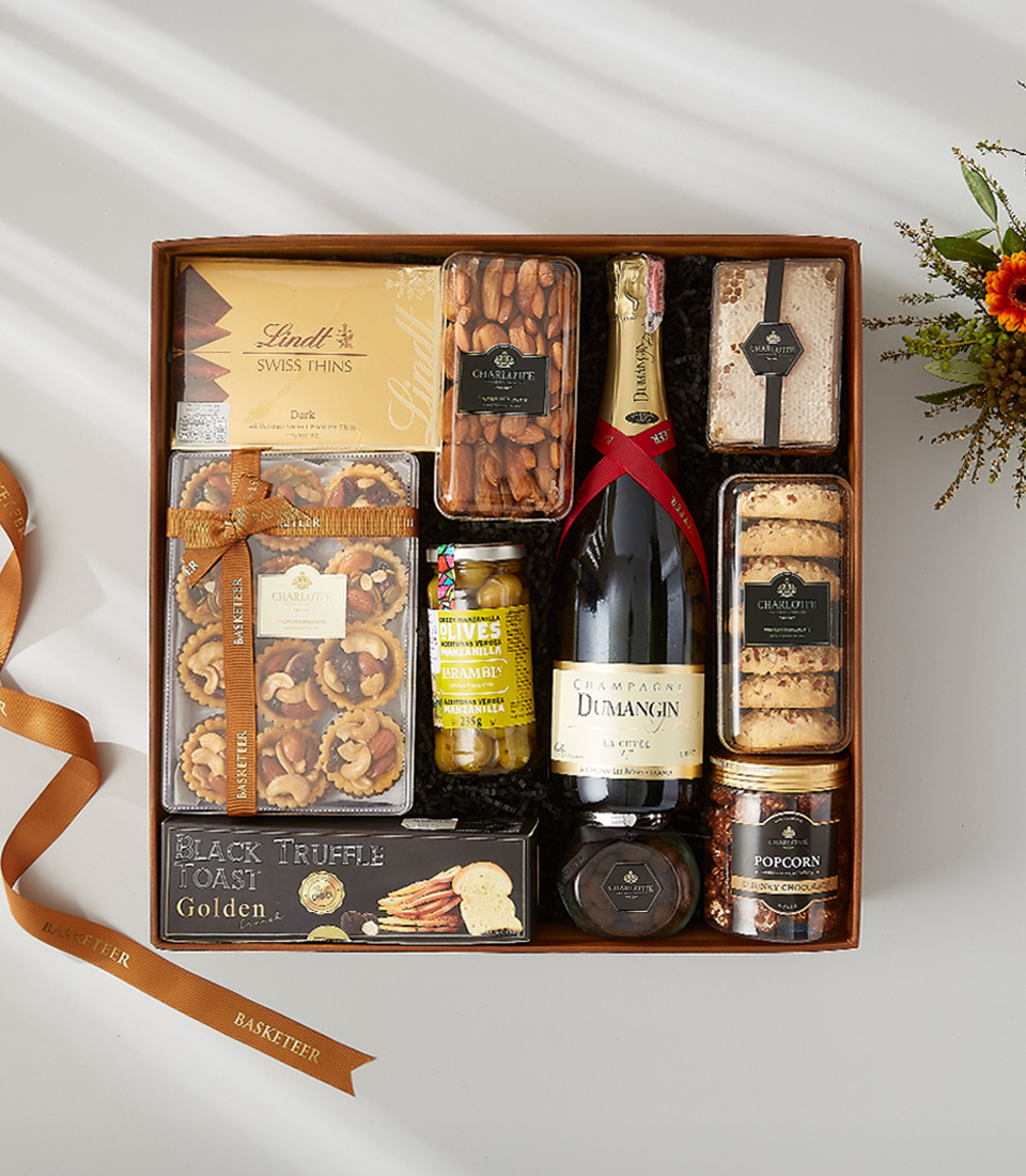 A luxurious and elegant gift basket filled with a bottle of wine, gourmet snacks, and holiday decorations.