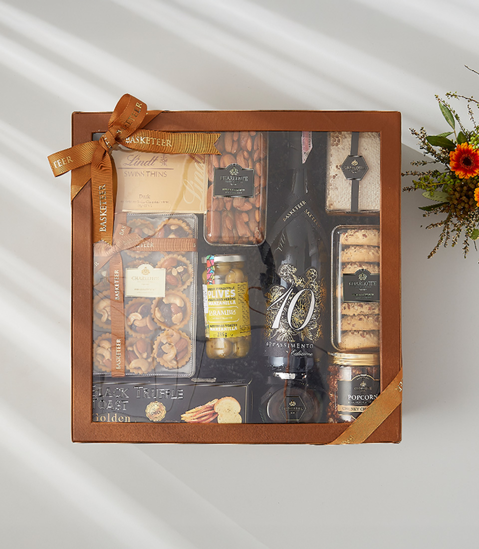 A festive gift hamper filled with a bottle of wine, delicious snacks, and festive decorations.