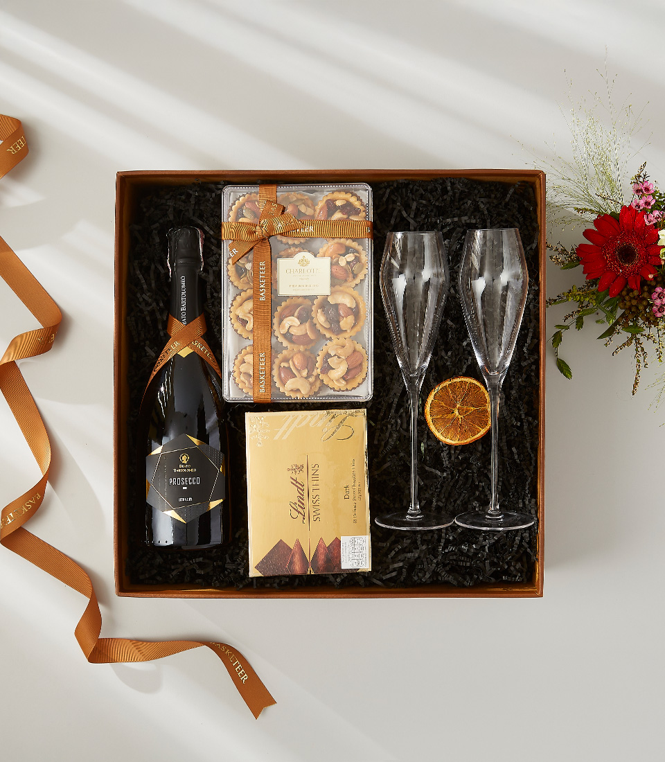 A luxurious and elegant gift basket filled with a bottle of champagne, gourmet snacks, and festive decorations.