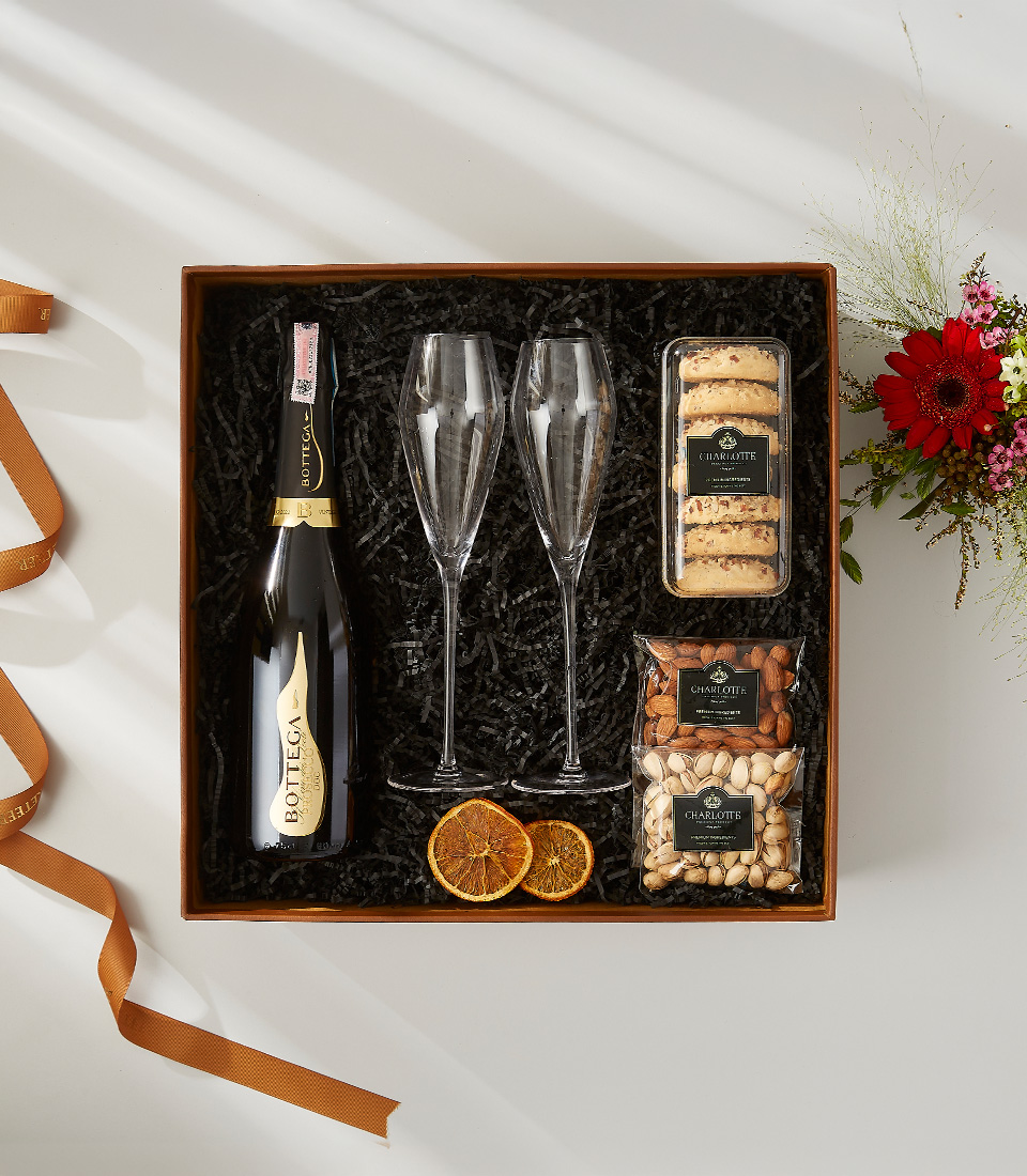 Bottega Gold Prosecco gift box with crystal champagne flutes, cookies, and nuts.
