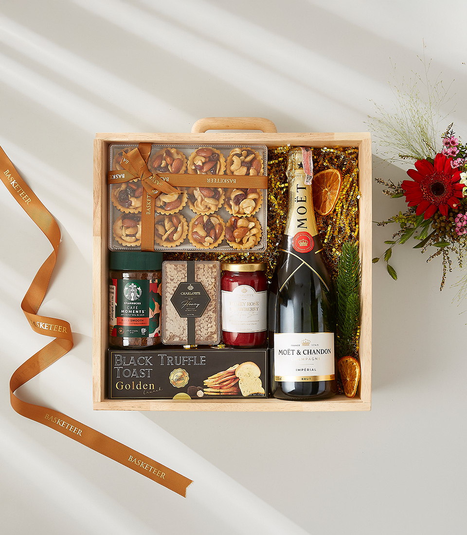 Wooden gift box with Moët & Chandon champagne, gourmet snacks, black truffle toast, honey, jam, and a Starbucks coffee blend.