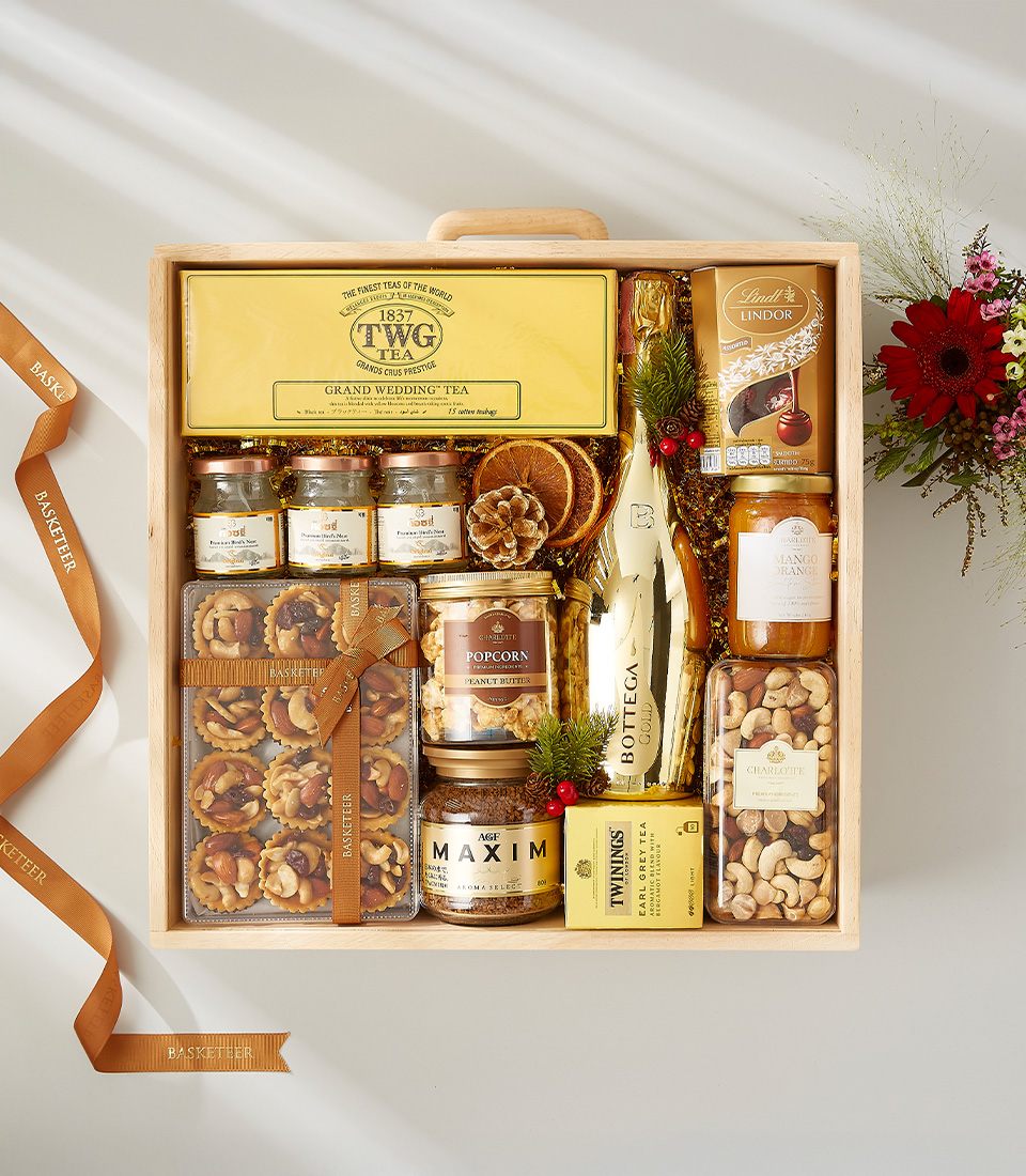 Luxury gift hamper containing a bottle of champagne, gourmet snacks, and premium tea.