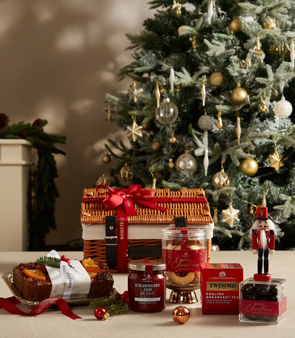 Festive holiday gift hamper with premium tea, strawberry jam, cookies, and treats, ideal for Christmas celebrations.