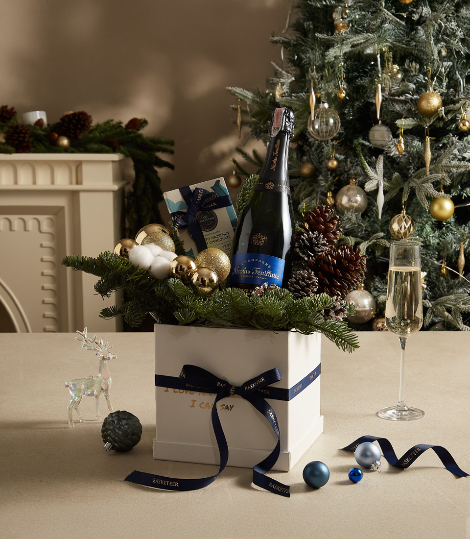 Holiday gift box adorned with greenery, golden ornaments, and gourmet treats, ideal for Christmas celebrations.