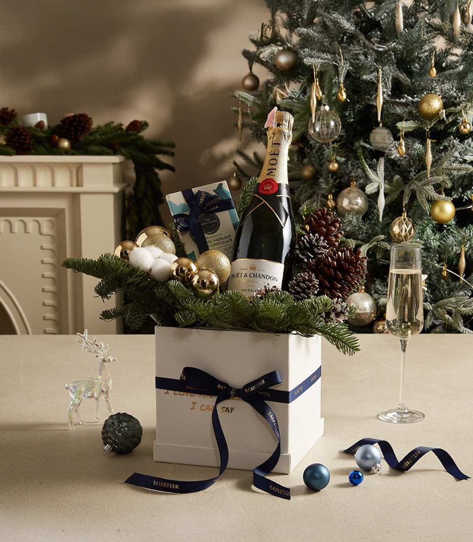 Elegant holiday gift box with premium chocolates, festive ornaments, and sparkling delights for celebrations.