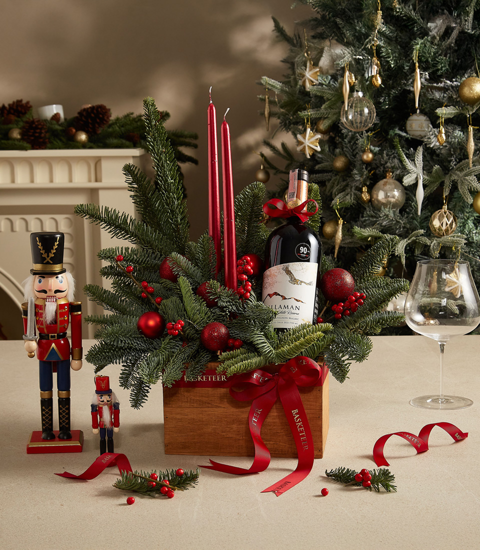 Festive holiday centerpiece box with red candles, greenery, and decorative accents, perfect for celebrations.