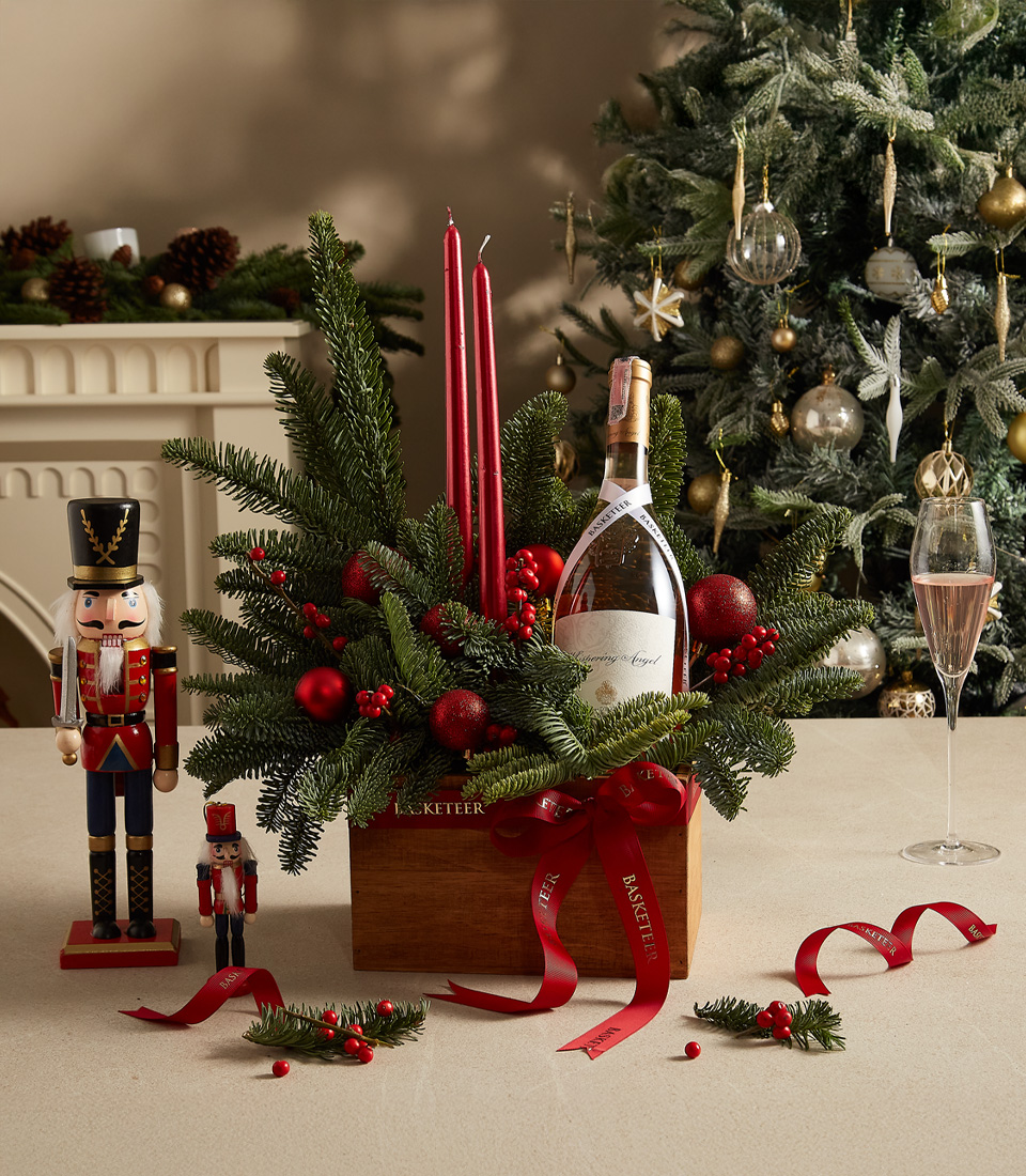 Elegant holiday candle box with red accents, fresh greenery, and festive decorations for seasonal charm.