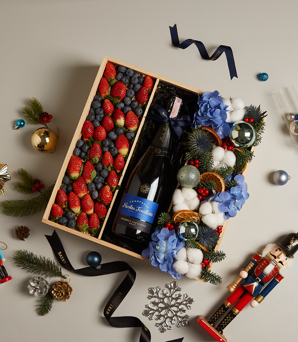 Elegant holiday gift tray with strawberries, blueberries, and festive floral decor for special celebrations.