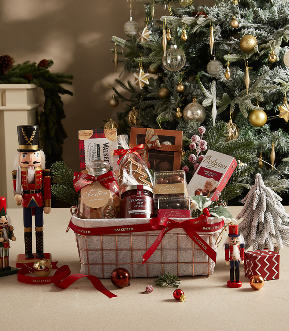 Deluxe Christmas treats basket with jam, chocolates, cookies, and festive accents for holiday celebrations.