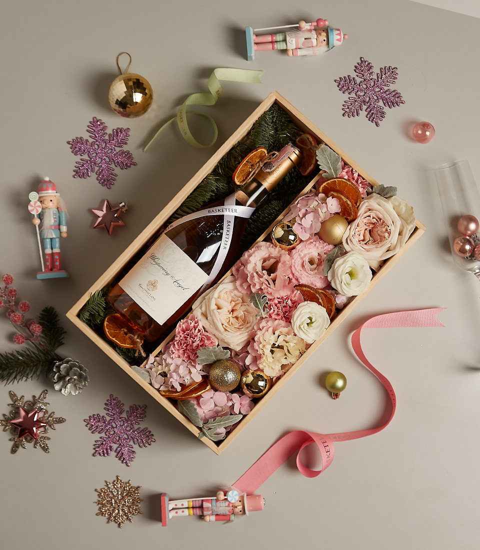 Luxury floral gift box with pastel blooms, golden accents, and festive decorations for the holiday season.