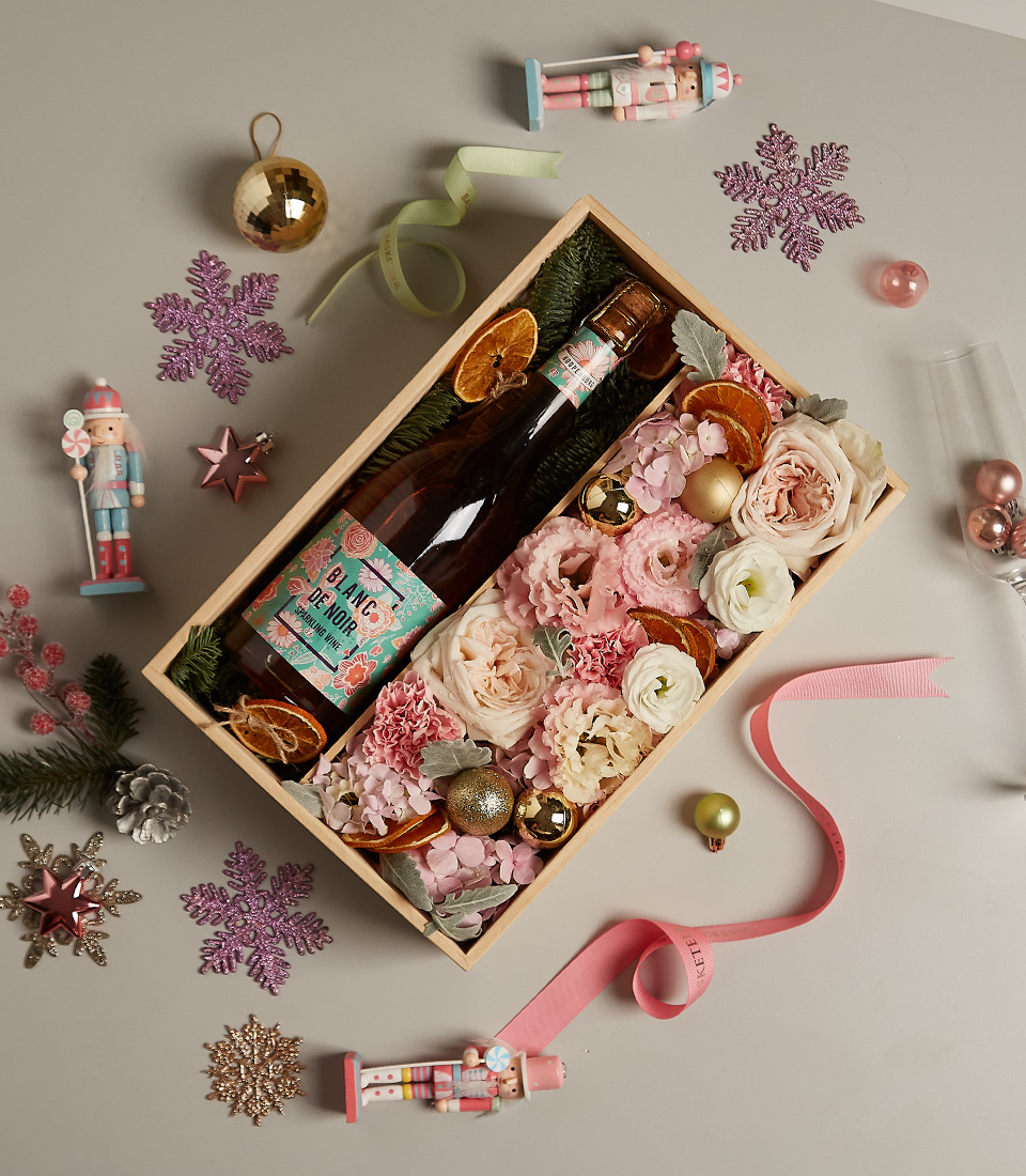 Floral gift box with pastel roses, golden accents, and festive decorations, ideal for special occasions.