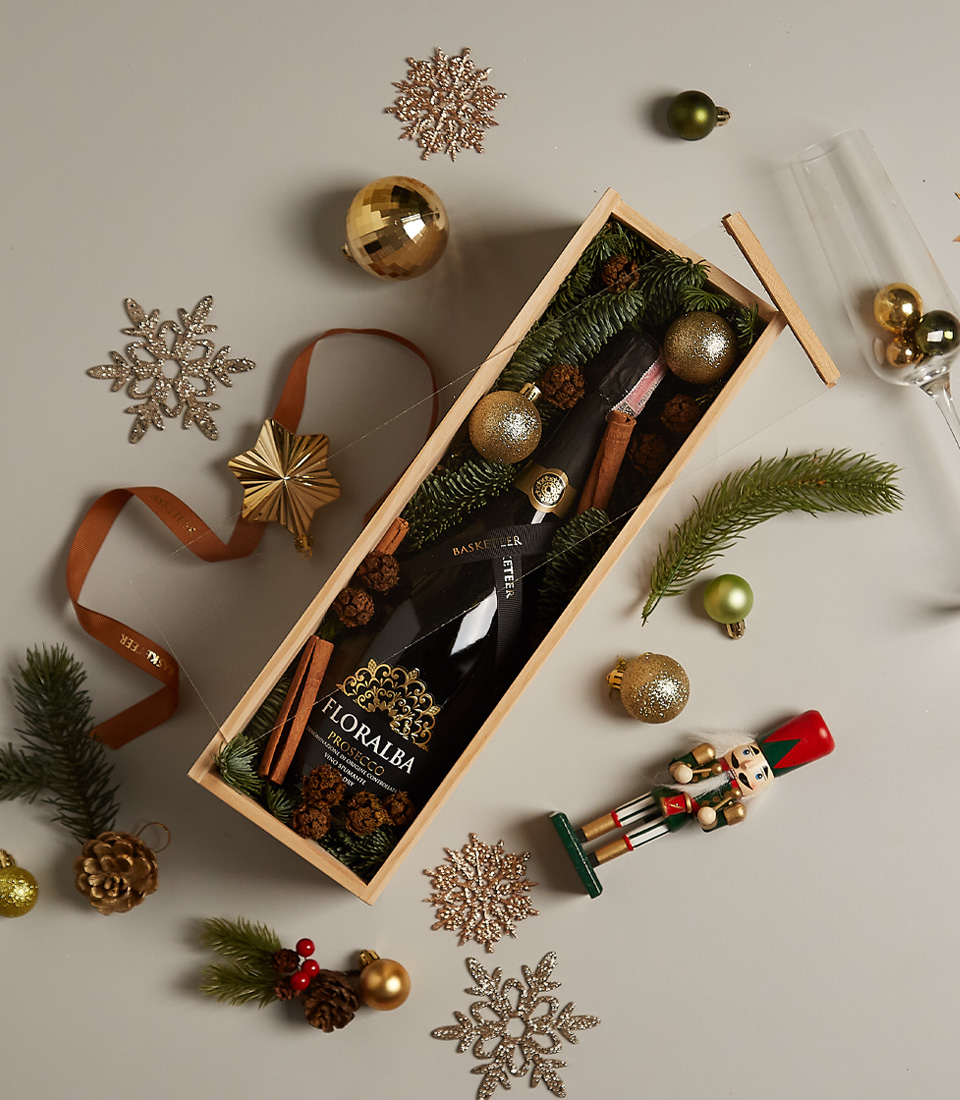 Gift box with sparkling delight, pinecone accents, and golden holiday decorations, ideal for festive occasions.