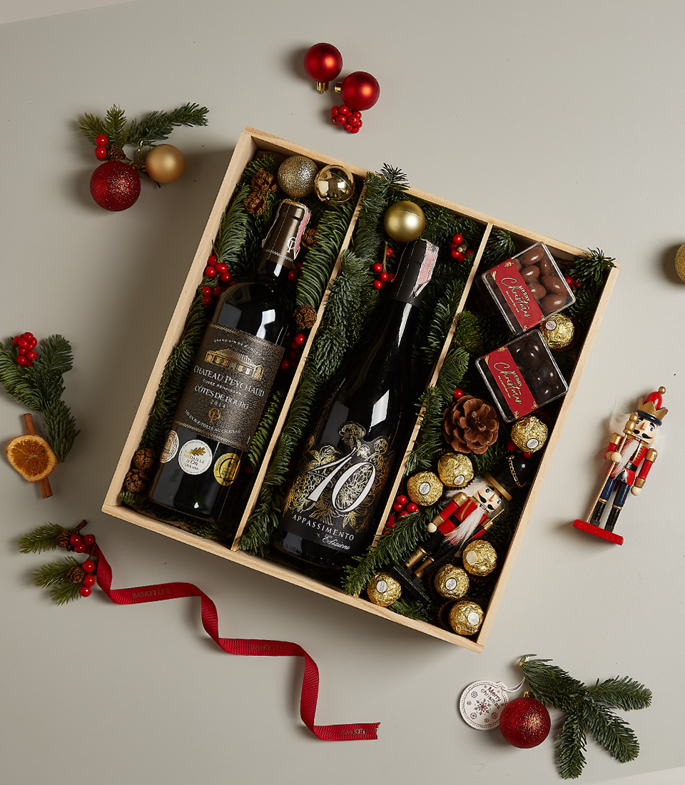 Premium holiday gift box featuring Château Peychaud red wine, Pasqua 10 Anniversario wine, Ferrero Rocher chocolates, nutcracker, and Christmas-themed decor.