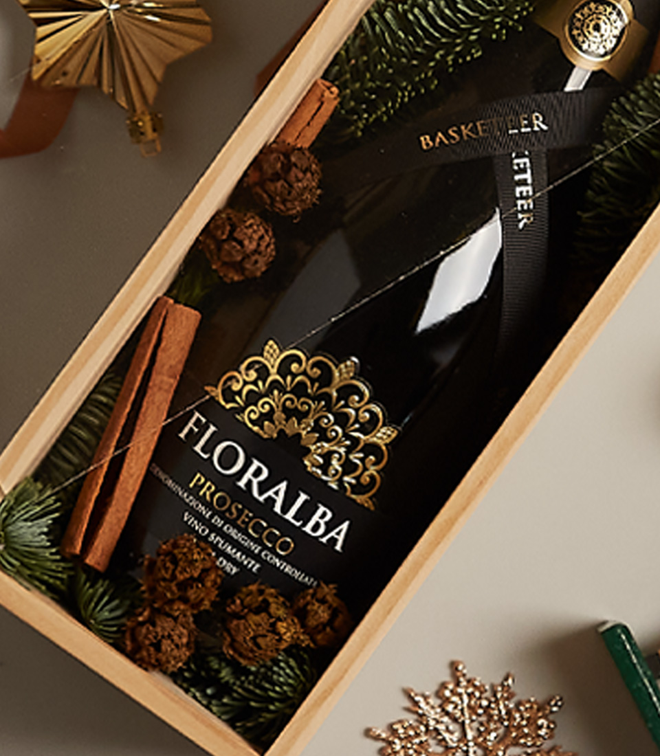 Gift box with sparkling delight, pinecone accents, and golden holiday decorations, ideal for festive occasions.