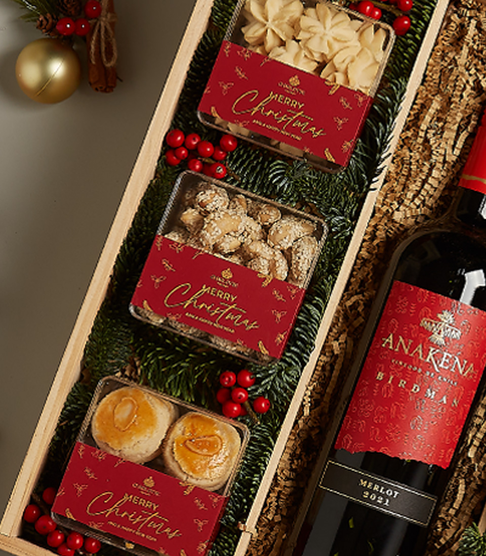 Elegant holiday gift box with red accents, festive treats, and a touch of seasonal luxury.