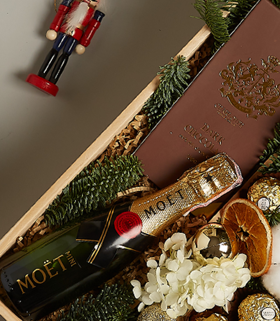 Exclusive luxury gift box with Moët Champagne, premium chocolates, and elegant golden holiday decor.
