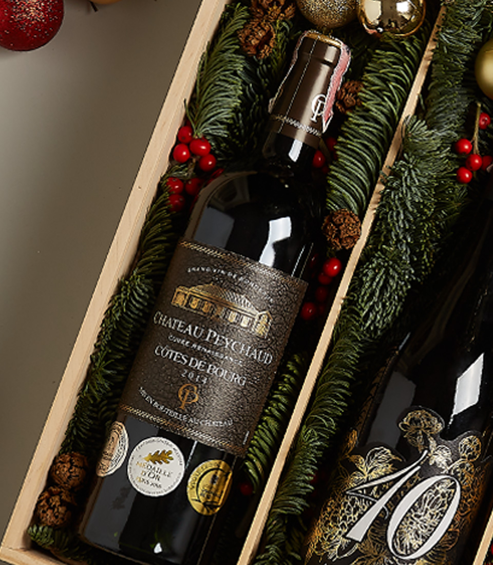 Premium holiday gift box featuring Château Peychaud red wine, Pasqua 10 Anniversario wine, Ferrero Rocher chocolates, nutcracker, and Christmas-themed decor.