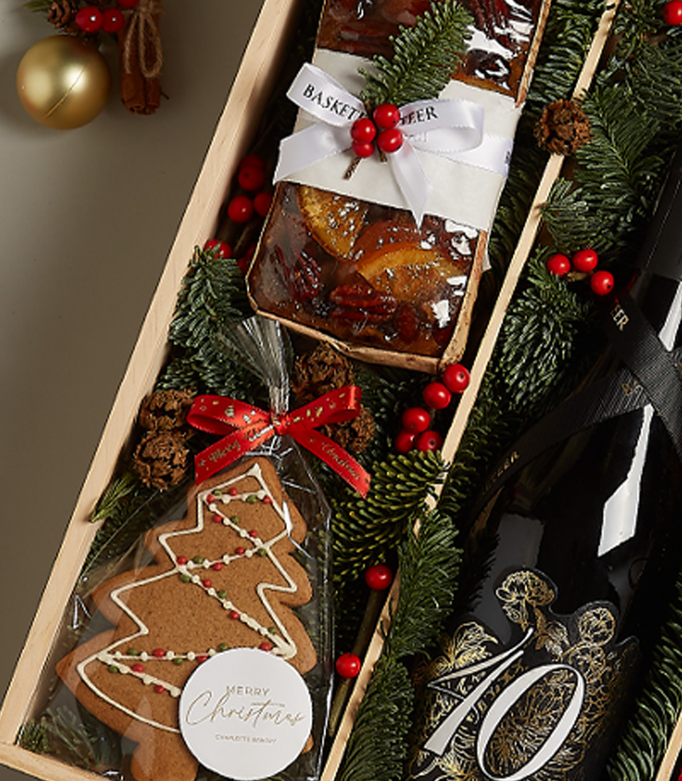 Festive deluxe holiday gift box with pastries, treats, and Christmas-themed decorations for seasonal joy.