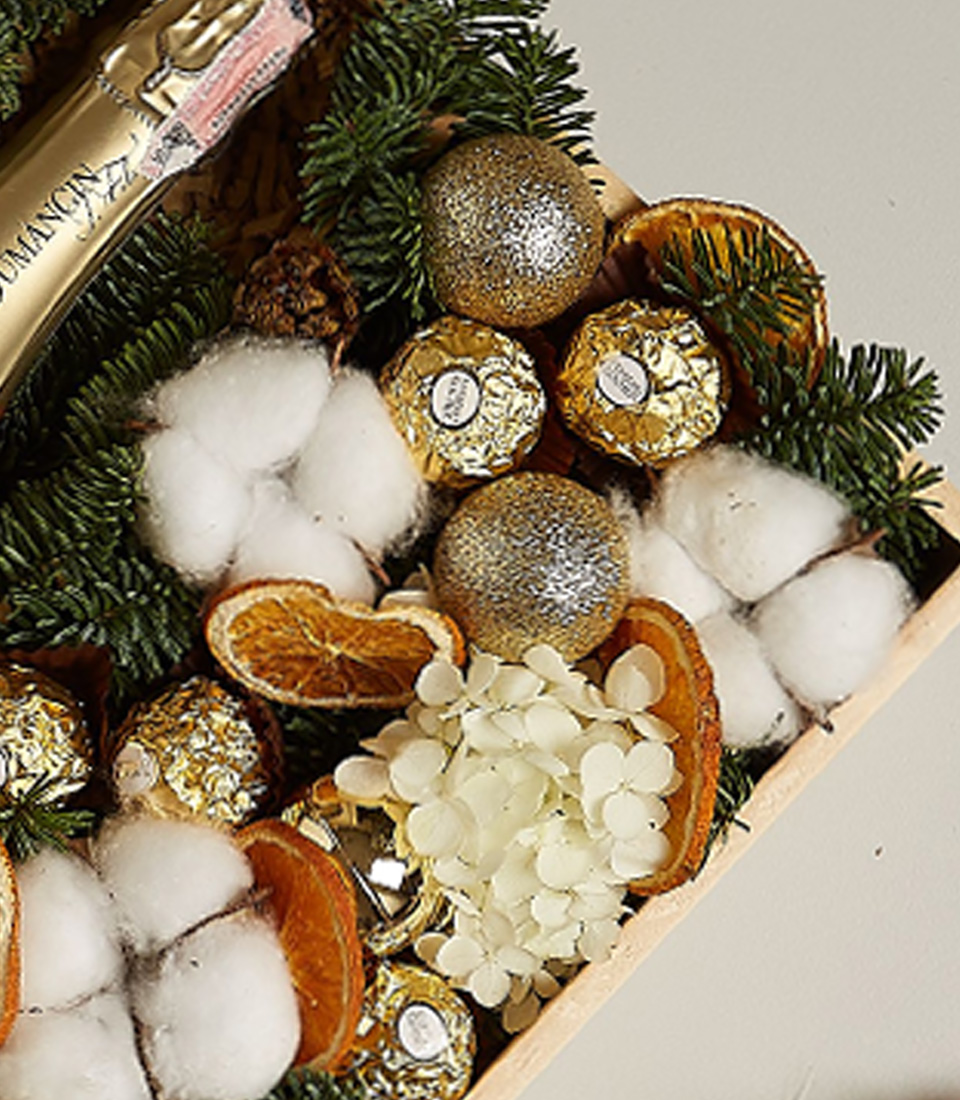 Luxury gift box with Dumangin Champagne, Ferrero Rocher chocolates, dried orange slices, cotton, hydrangeas, and festive decorations.