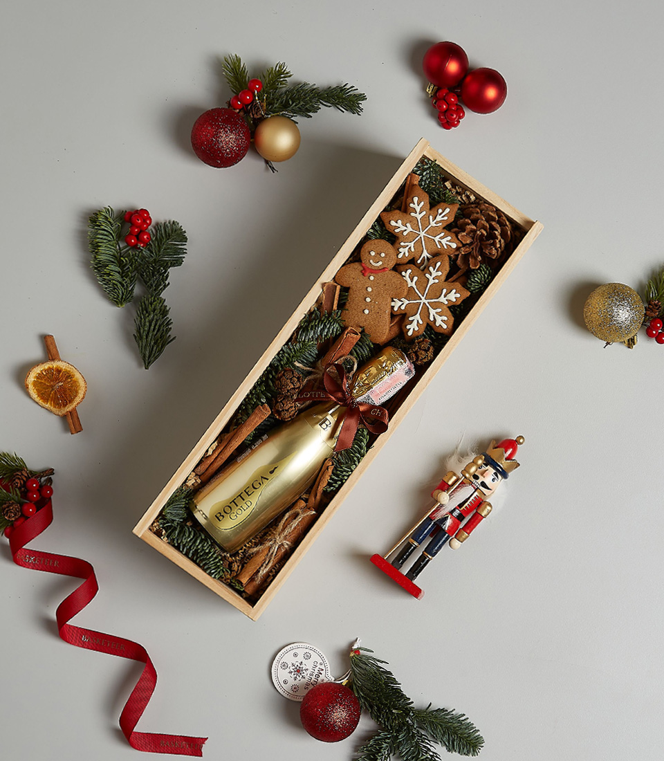 Holiday gift box with Bottega Gold Prosecco, gingerbread cookies, snowflake ornaments, and festive decorations.