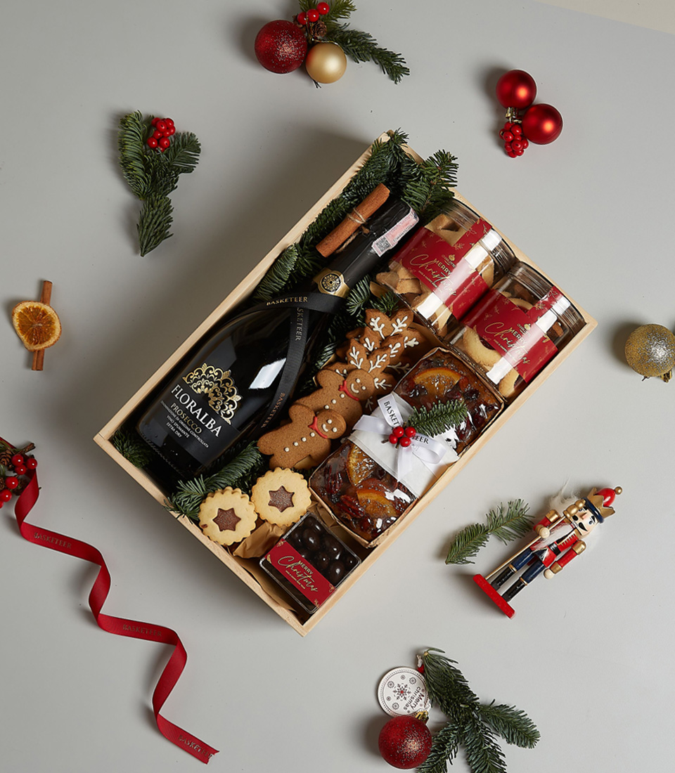 Holiday gift box featuring Floralba Prosecco, gingerbread cookies, biscuits, fruitcake, chocolates, and festive decorations.