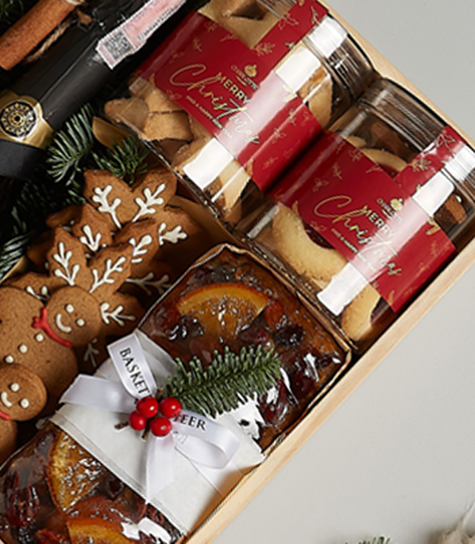 Holiday gift box featuring Floralba Prosecco, gingerbread cookies, biscuits, fruitcake, chocolates, and festive decorations.