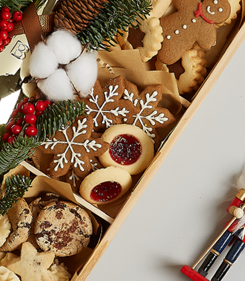 Holiday gift box with Bottega Gold sparkling wine, festive cookies, gingerbread, snowflake treats, and holiday greenery decorations.