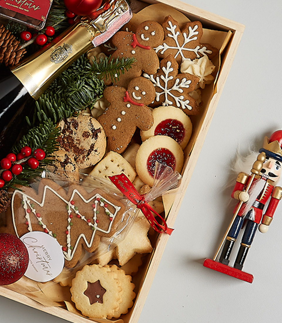 Luxury Christmas gift box with Champagne Dumangin, gingerbread cookies, chocolates, shortbread biscuits, festive greenery, and a nutcracker.