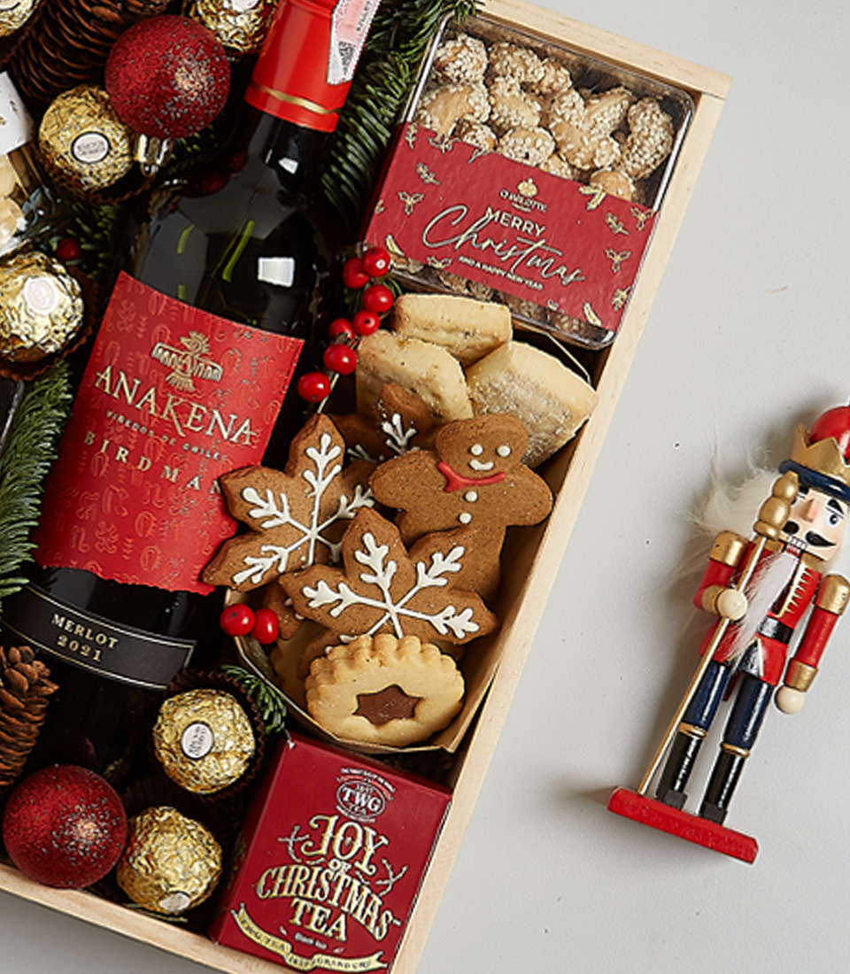 Christmas gift box with Anakena Cabernet Sauvignon, mince pies, Ferrero Rocher chocolates, gingerbread cookies, festive greenery, and a nutcracker ornament.