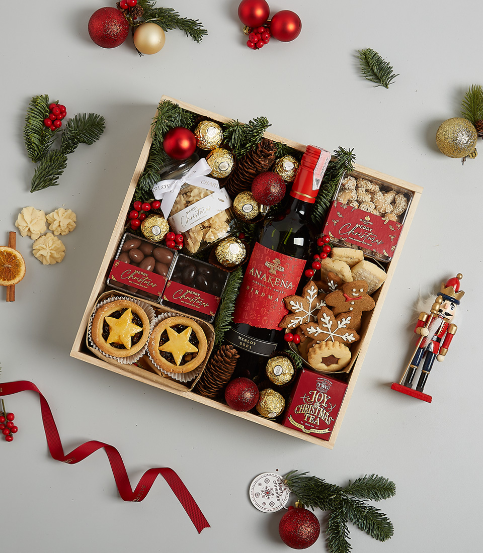 Christmas gift box with Anakena Cabernet Sauvignon, mince pies, Ferrero Rocher chocolates, gingerbread cookies, festive greenery, and a nutcracker ornament.