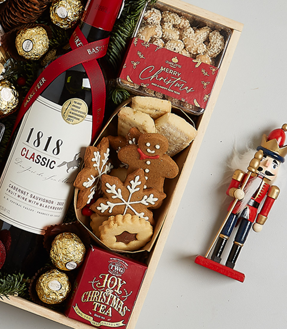 Elegant Christmas gift box with 1818 Classic Red Wine, Ferrero Rocher chocolates, mince pies, gingerbread cookies, and holiday decorations.