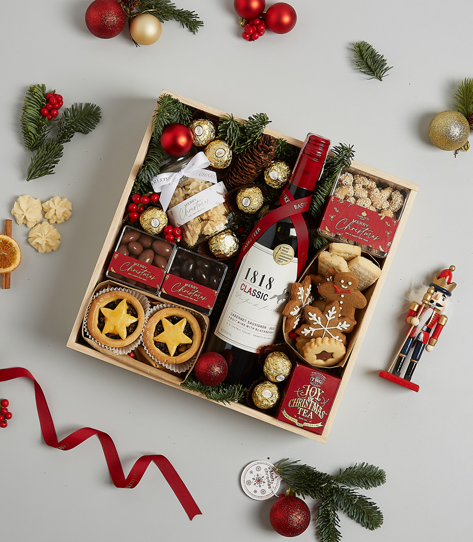 Elegant Christmas gift box with 1818 Classic Red Wine, Ferrero Rocher chocolates, mince pies, gingerbread cookies, and holiday decorations.