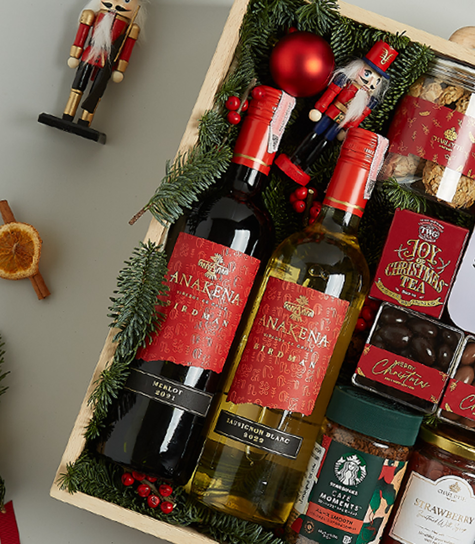 Festive wooden hamper with Anakena red and white wines, Christmas pudding, shortbread, chocolates, preserves, and holiday decor.