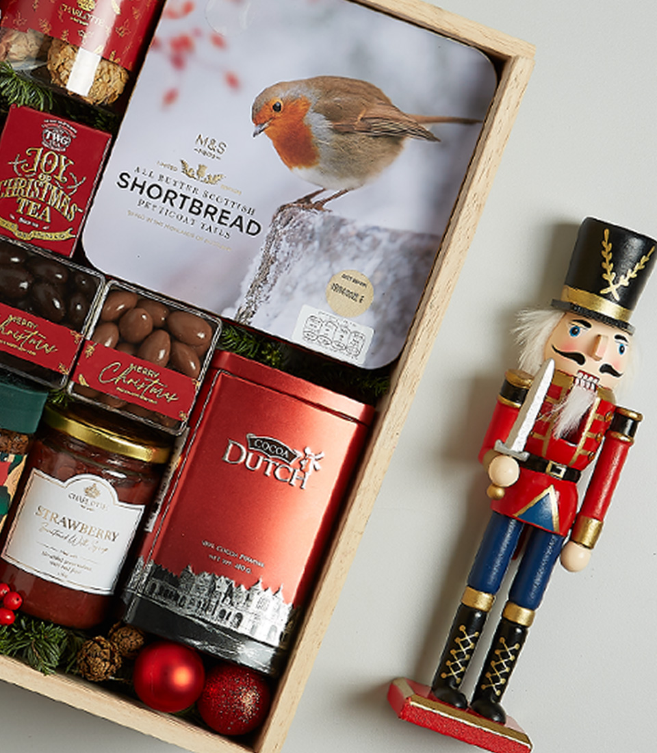 Festive wooden hamper with Anakena red and white wines, Christmas pudding, shortbread, chocolates, preserves, and holiday decor.