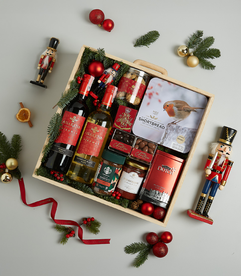 Festive wooden hamper with Anakena red and white wines, Christmas pudding, shortbread, chocolates, preserves, and holiday decor.