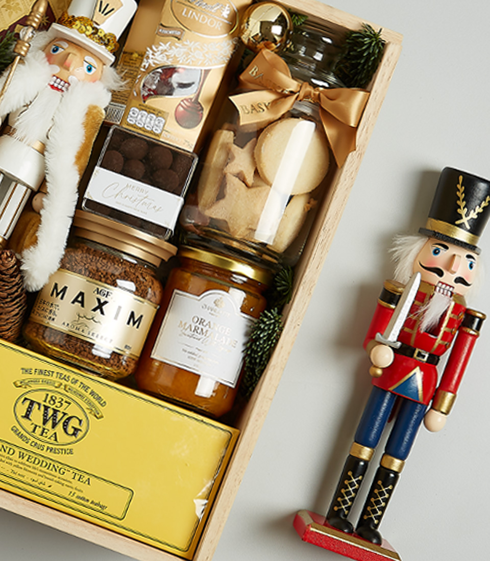 Christmas gift hamper with Bottega Gold prosecco, TWG tea, gourmet honey, artisanal cookies, chocolates, and Nutcracker decoration in festive packaging.