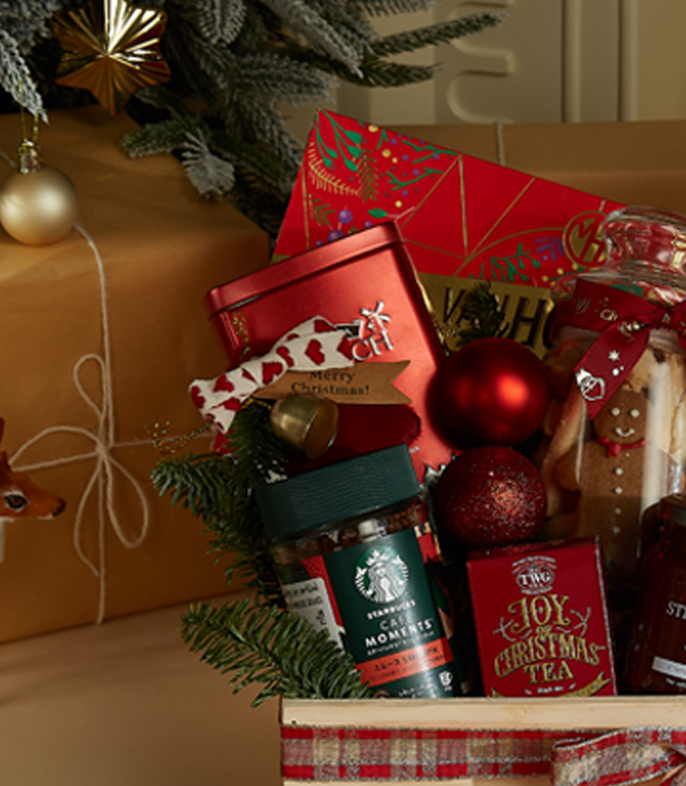 Festive wooden gift hamper featuring Lindt chocolates, holiday cookies, Christmas tea, strawberry preserves, and a plush Santa bear.