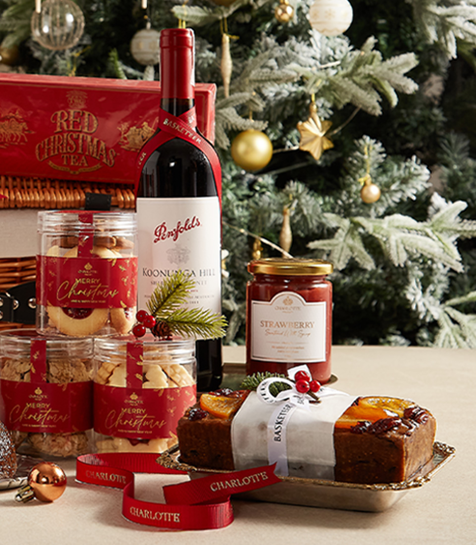 Luxurious Christmas hamper with festive treats, sweets, and tea, beautifully wrapped for the holidays.