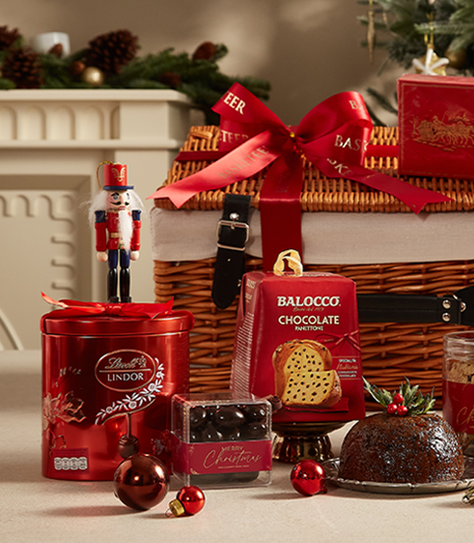 Luxurious Christmas hamper with festive treats, sweets, and tea, beautifully wrapped for the holidays.