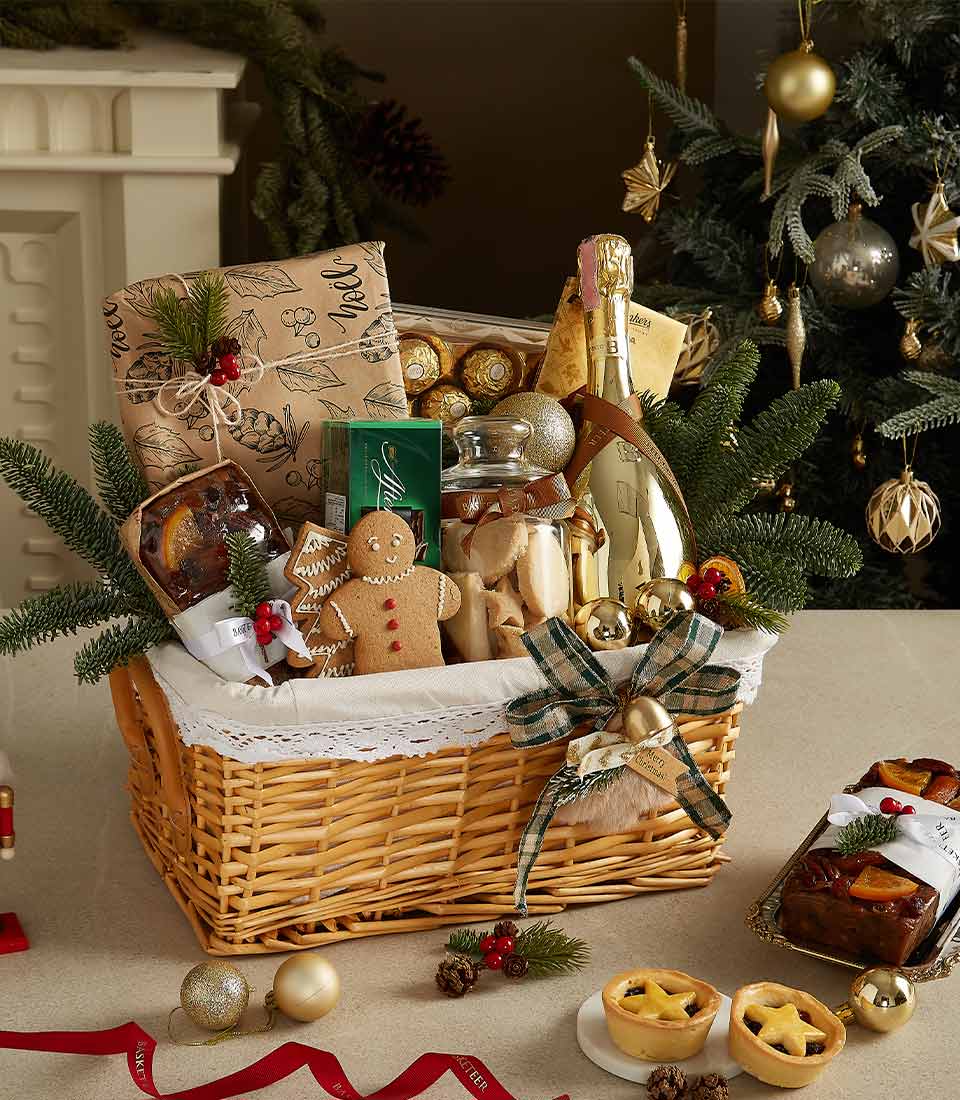 Luxurious Christmas gift basket featuring Bottega Gold Prosecco, gingerbread cookies, fruitcake, mince pies, and chocolates with festive decorations.