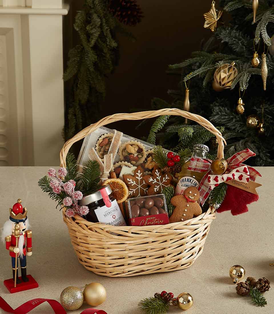 Christmas gift basket with gingerbread cookies, Baileys Irish Cream, chocolates, shortbread, and festive decorations.