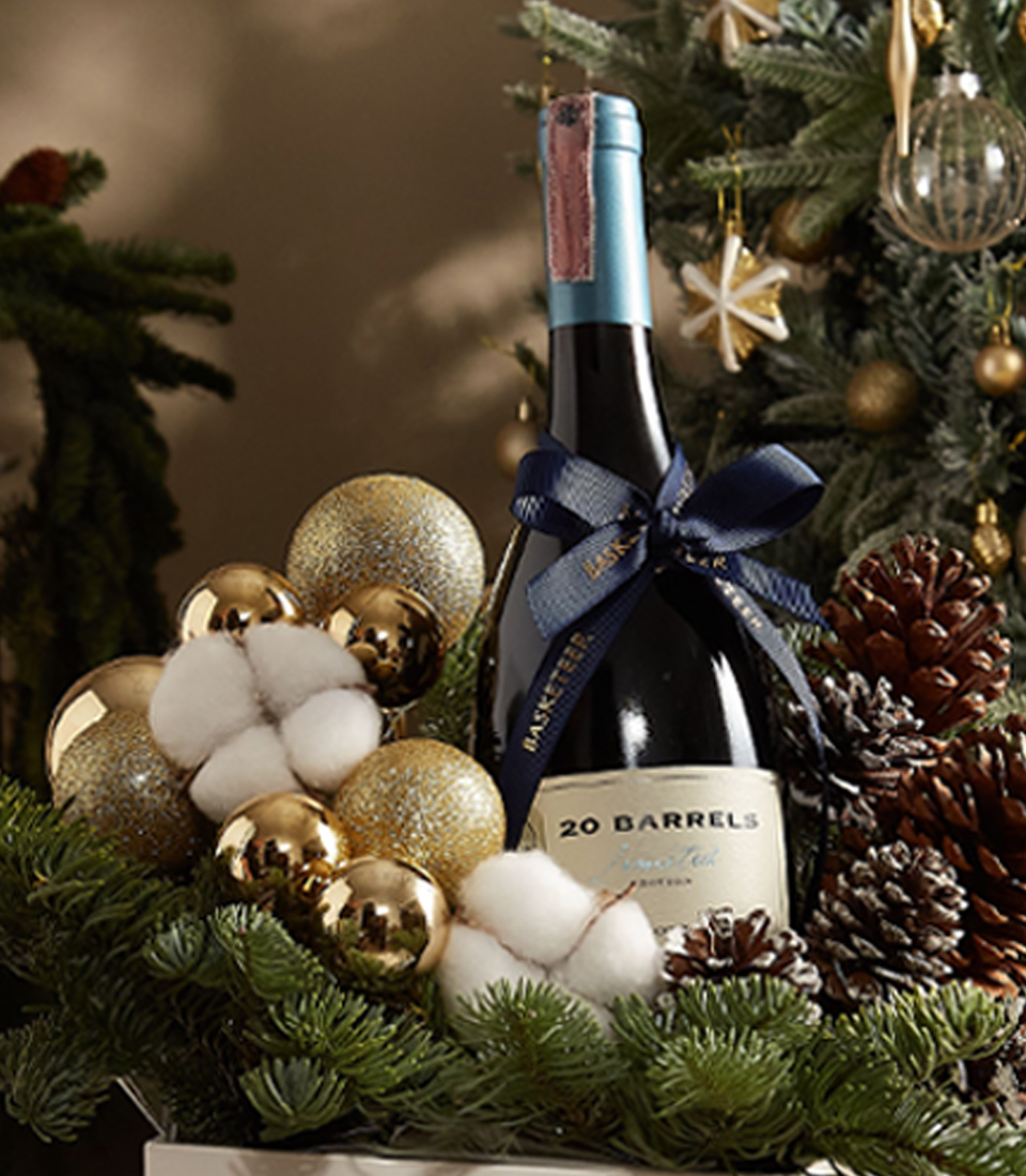 White Christmas gift box with pine greenery, ornaments, and festive decorations for a joyful holiday presentation.