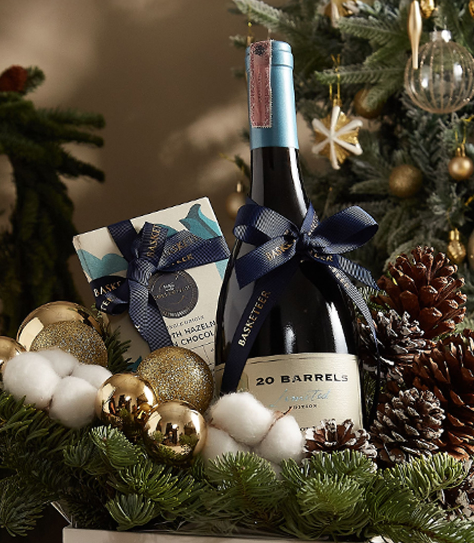 Christmas gift box with pine greenery, ornaments, and premium holiday treats, ideal for festive gifting.