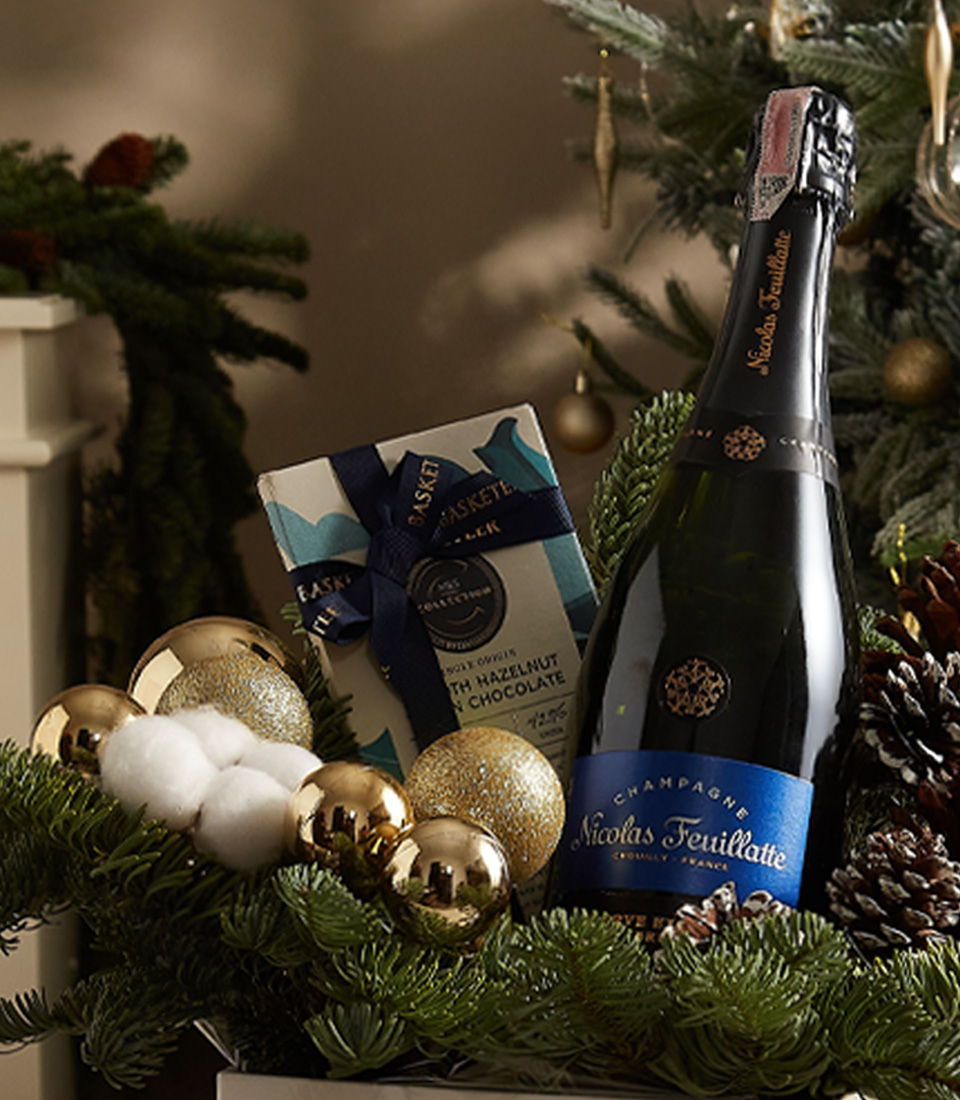 Holiday gift box adorned with greenery, golden ornaments, and gourmet treats, ideal for Christmas celebrations.