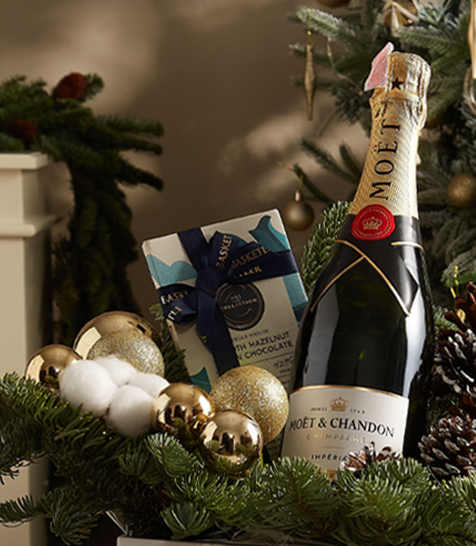 Elegant holiday gift box with premium chocolates, festive ornaments, and sparkling delights for celebrations.