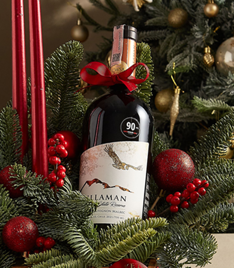 Festive holiday centerpiece box with red candles, greenery, and decorative accents, perfect for celebrations.