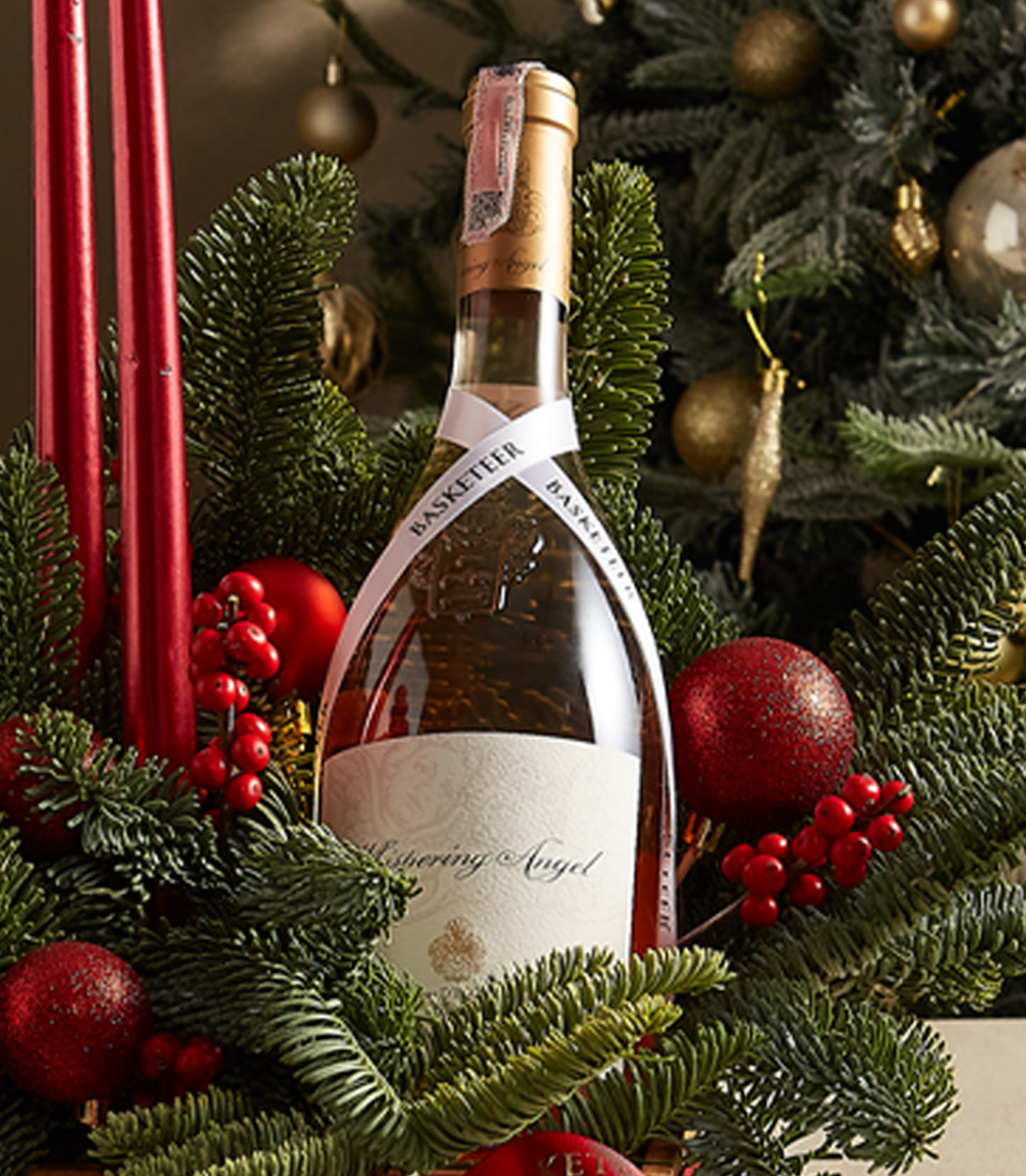 Elegant holiday candle box with red accents, fresh greenery, and festive decorations for seasonal charm.