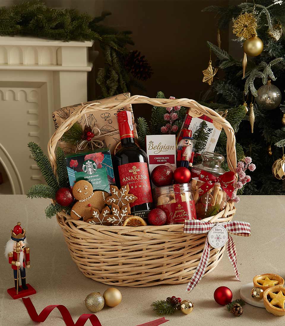 Christmas gift basket with red wine, Belgian chocolates, gingerbread cookies, biscotti, and festive decorations.