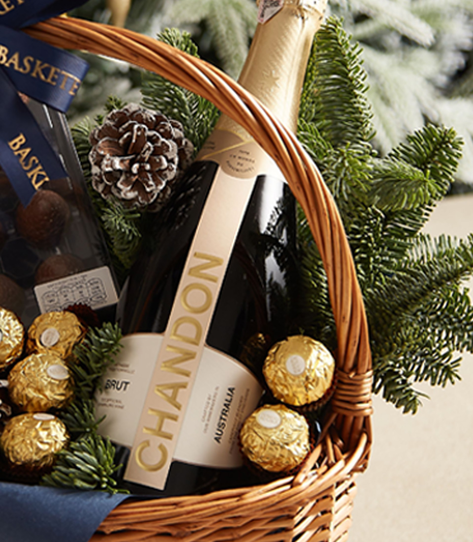 Holiday gift basket with blue ribbon, festive greenery, and premium treats for a perfect seasonal gift.